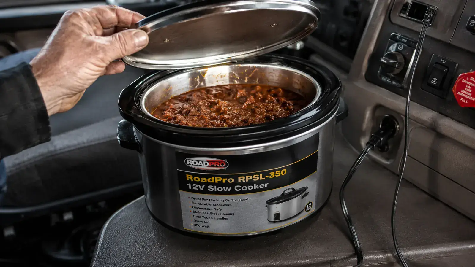 RoadPro RPSL-350 slow cooker with lid open showing chili inside, power cord plugged into a 12V lighter socket