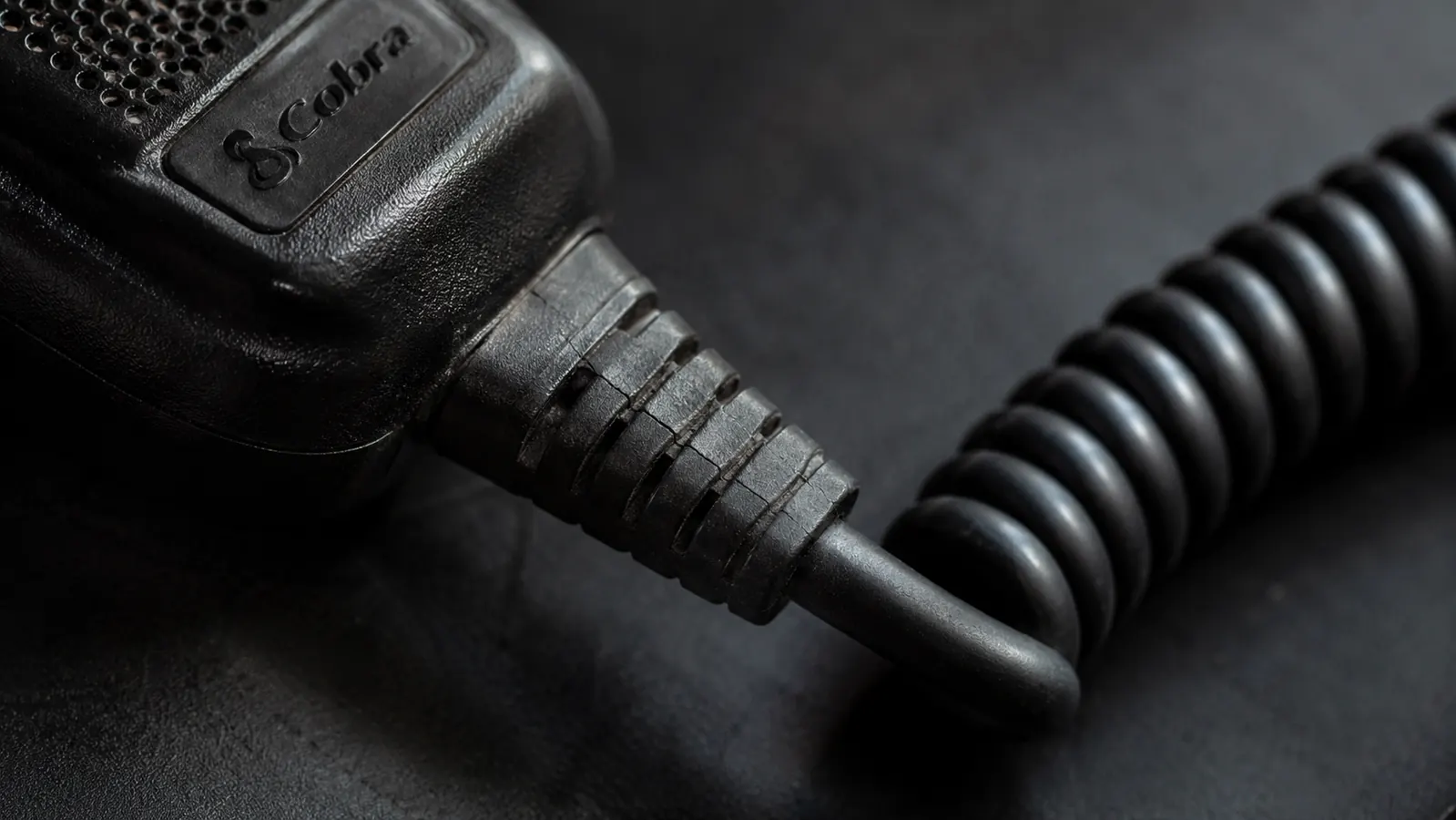 Close-up of the coiled microphone cord on the Uniden BEARCAT 980 showing the stress point near the mic body